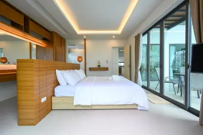 a bedroom with a large bed and a balcony at New Luxury Pool Villa Bangtao Phuket in Ban Pak Lak