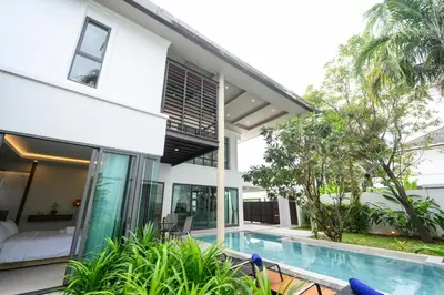 a villa with a swimming pool and a house at New Luxury Pool Villa Bangtao Phuket in Ban Pak Lak
