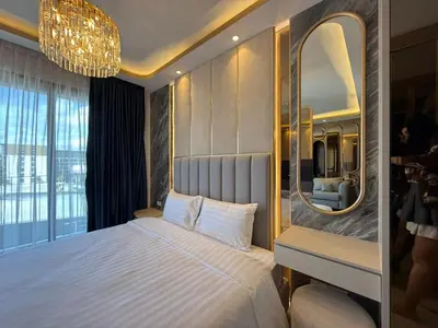 a bedroom with a large bed and a mirror at Bangtao new studio in Bellevue Lagoon in Laguna Phuket