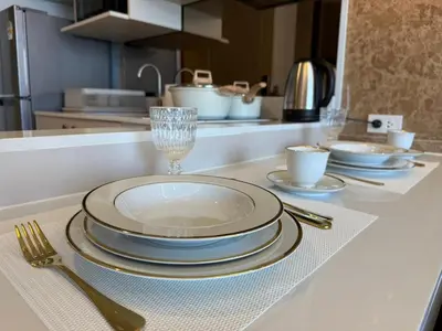 a table with plates and glasses on a kitchen counter at Bangtao new studio in Bellevue Lagoon in Laguna Phuket