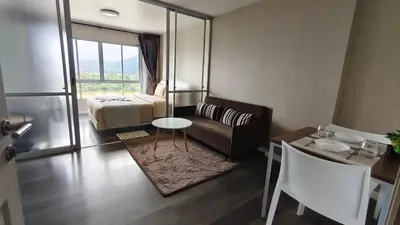 a living room with a couch and a bed and a table at The Azure Kathu in Kathu