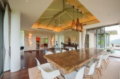 a dining room with a large table and white chairs at Tropical Castle Villa in Phuket Town