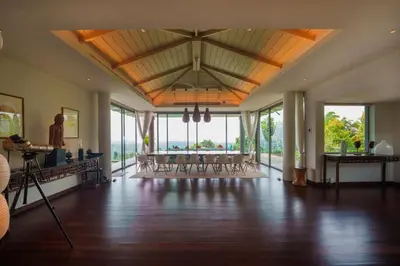 a large room with chairs and a ceiling with windows at Tropical Castle Villa in Phuket Town
