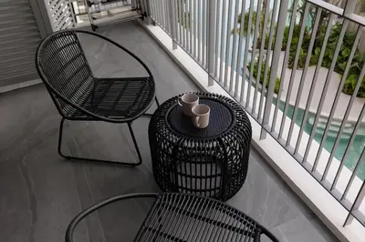 a balcony with two chairs and a table with cups on it at Cute apartment 52 m2 in Brand New condo! BangTao in Bang Tao Beach