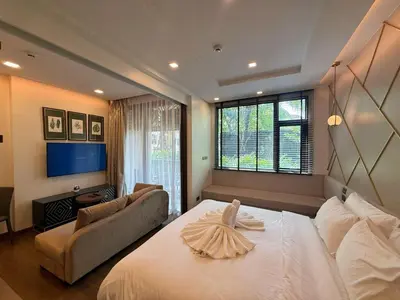 a bedroom with a large white bed and a couch at New Apartment on the 1floor in The Proud Karon in Karon Beach