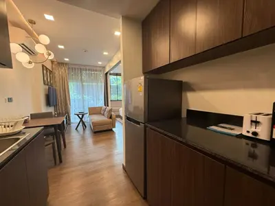 a kitchen with a refrigerator and a living room at New Apartment on the 1floor in The Proud Karon in Karon Beach