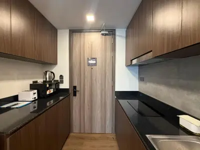 a kitchen with a wooden door and a sink at New Apartment on the 1floor in The Proud Karon in Karon Beach