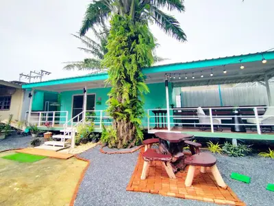 a house with a palm tree in front of it at Palm Garden house 1 close to Bang Tao beach in Ban Phak Chit