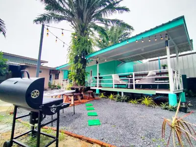 a house with a grill in front of it at Palm Garden house 1 close to Bang Tao beach in Ban Phak Chit