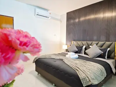 a bedroom with a large bed and pink flowers at 4 bedroom Lucky House Patong in Patong Beach