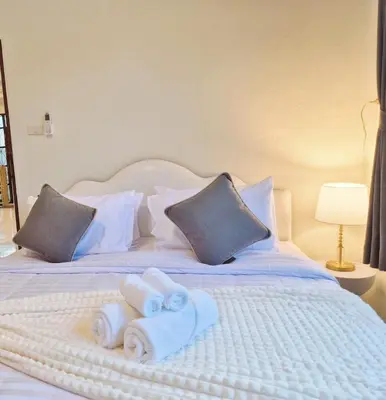 a white bed with towels and pillows on it at 4 bedroom Lucky House Patong in Patong Beach