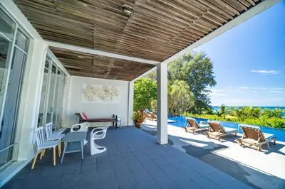 a patio with a table and chairs and a pool at Black Pearl 8 Bedroom Beach Villa Private Pool Gym Free Car Free Water and Electricity Maid 10 Meters to the Beach in Mai Khao Beach