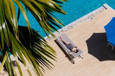 a man laying on a chair next to a swimming pool at BlueSotel Krabi AoNang Beach in Ao Nang Beach