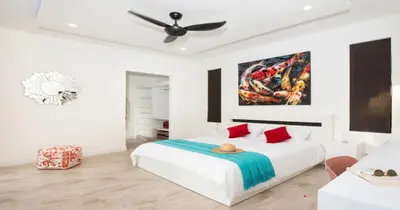 a white bedroom with a bed and a ceiling fan at Stunning Pool Villa Curtis - 5 Bedrooms in the heart of Rawai in Rawai Beach