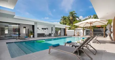 a pool with chairs and a table and a house at Stunning Pool Villa Curtis - 5 Bedrooms in the heart of Rawai in Rawai Beach