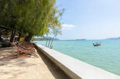 a couple of chairs sitting next to the water at Holiday Villa 2-BR J10, Private Pool, Rawai Beach in Phuket Town