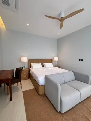 a bedroom with a bed and a couch and a table at Phuket Moana Pool Villa in Ban Na Nai
