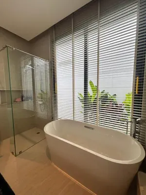 a bathroom with a large white tub and a window at Phuket Moana Pool Villa in Ban Na Nai