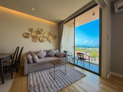 a living room with a couch and a table and a large window at Luxury room with Seaview in Ao Nang Beach