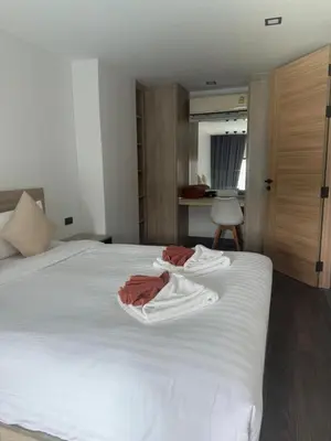 two towels are sitting on top of a white bed at Utopia Lofts by Sabai Sands in Nai Harn Beach