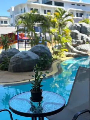 a potted plant sitting on a table next to a pool at Utopia Lofts by Sabai Sands in Nai Harn Beach