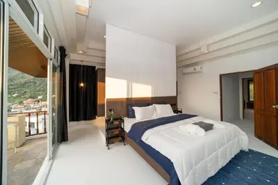 a bedroom with a large bed and a balcony at Patong Thai-style 4 Bedrooms Private Pool Sunset View Deck 6 Minutes to the Beach in Patong Beach