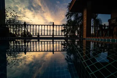 a view of a pool with a sunset in the background at Patong Thai-style 4 Bedrooms Private Pool Sunset View Deck 6 Minutes to the Beach in Patong Beach