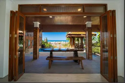 an open door to a patio with a table at Patong Thai-style 4 Bedrooms Private Pool Sunset View Deck 6 Minutes to the Beach in Patong Beach