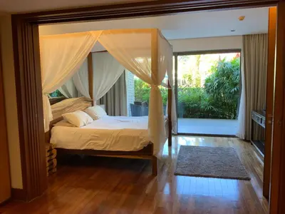 a bedroom with a canopy bed with a window at Pearl of Nai Thon in Nai Thon Beach