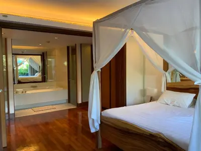 a bedroom with a canopy bed and a bathroom at Pearl of Nai Thon in Nai Thon Beach