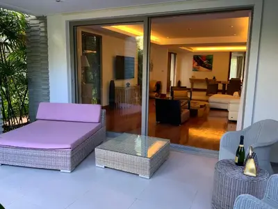 a patio with a purple couch and a living room at Pearl of Nai Thon in Nai Thon Beach