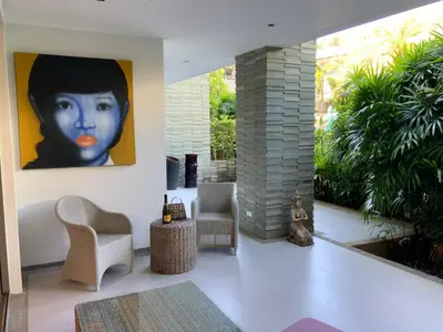 a living room with a painting of a woman at Pearl of Nai Thon in Nai Thon Beach