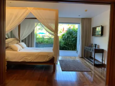 a bedroom with a canopy bed and a large window at Pearl of Nai Thon in Nai Thon Beach