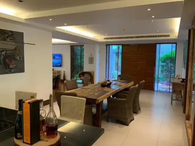 a dining room with a wooden table and chairs at Pearl of Nai Thon in Nai Thon Beach