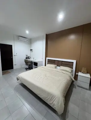 a bedroom with a large bed and a desk at Palai House in Ban Na Bon