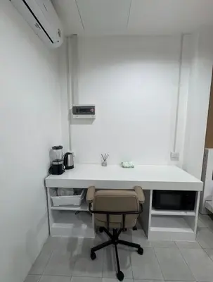 a white desk with a chair in a room at Palai House in Ban Na Bon