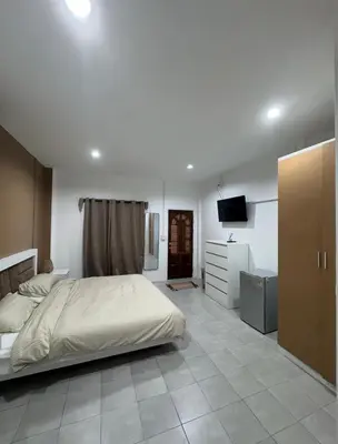 a bedroom with a bed and a television in it at Palai House in Ban Na Bon