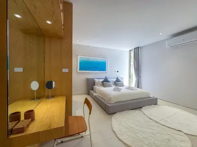 a bedroom with a large bed and a table at NEW! Luxury Pool Villa 4 Bedrooms in Lux Pride L27 Residence in Ban Pak Lak