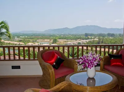 a balcony with chairs and a table with a vase of flowers at Villa Oriole - Luxury Pool Villa in Layan Beach