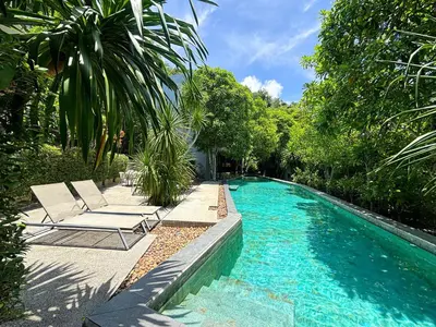 a swimming pool with two lounge chairs next to it at Design Duplex Pavillion 2 BR Natural Park P11 in Kamala Beach