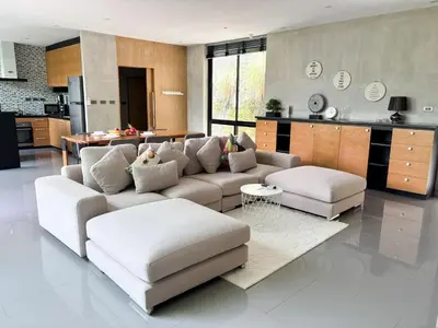 a living room with a couch and a kitchen at Design Duplex Pavillion 2 BR Natural Park P11 in Kamala Beach