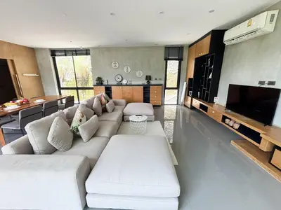a living room with a white couch and a television at Design Duplex Pavillion 2 BR Natural Park P11 in Kamala Beach