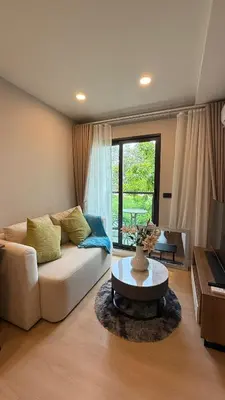 a living room with a couch and a table at Space Cherngtalay Condo in bangtao by sahana in Bang Tao Beach
