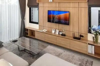a living room with a tv on a wall at Holiday Villa M9 with Private Pool, 300m Rawai beach in Phuket Town