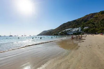 a group of people walking on a beach at Holiday Villa M9 with Private Pool, 300m Rawai beach in Phuket Town