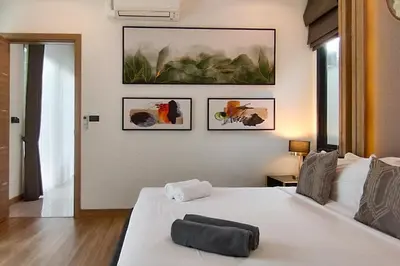 a bedroom with a white bed and some pictures on the wall at Tropical villa Sweet Dreams R20, Private Pool, Rawai Beach in Phuket Town