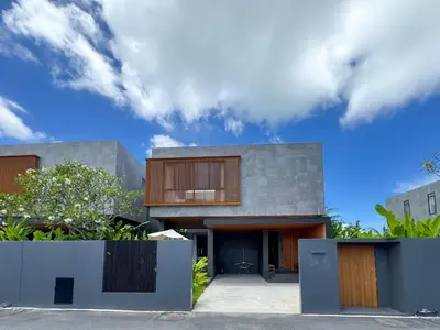 a modern house with wooden doors and a cloudy sky at Luxury 3-Bedroom Pool Villa Long One B9 with Panoramic Chalong Bay View in Ban Bo Rae