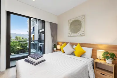 a bedroom with a bed and a large window at Laguna Lakeside BangTao Phuket in Bang Tao Beach