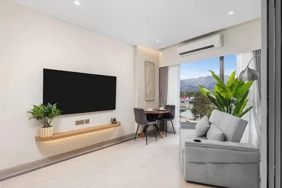 a living room with a flat screen tv on a wall at Laguna Lakeside BangTao Phuket in Bang Tao Beach