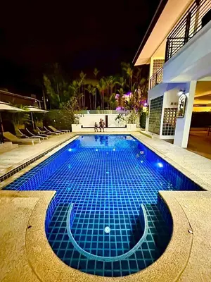 a swimming pool with blue tiles in front of a building at The White House Kamala II in Kamala Beach